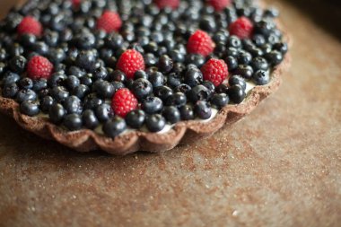 Taze meyveli tart. Ahududu ve üzümlü tart. Kırsal bir zeminde tatlı bir tatlı