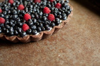 Taze meyveli tart. Ahududu ve üzümlü tart. Kırsal bir zeminde tatlı bir tatlı