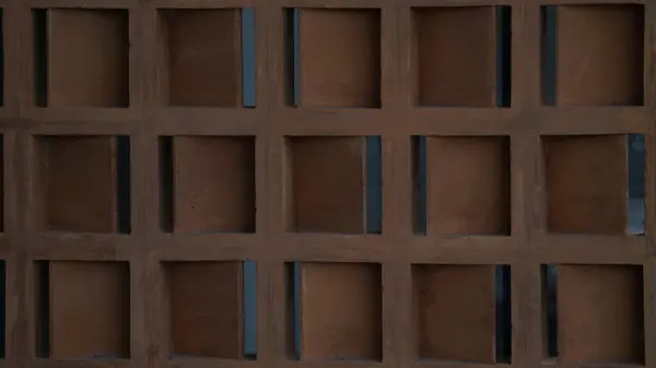 Detaylı desenli duvar havalandırması ve ızgara benzeri bir desen içeren mimari tasarım.