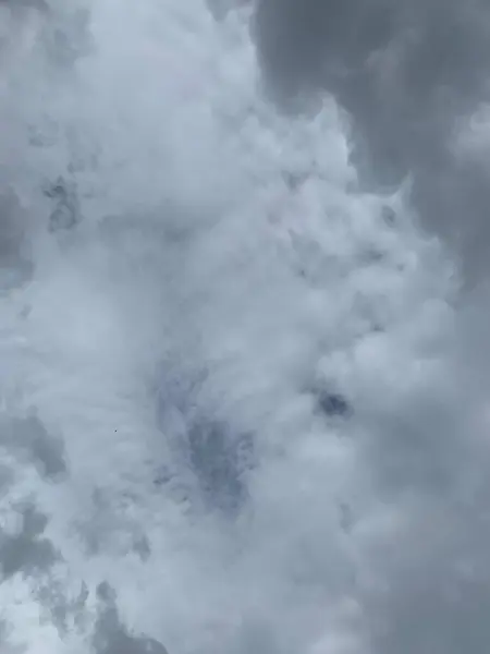 Parlak mavi gökyüzünde süzülen tüylü bulutların huzurlu manzarası