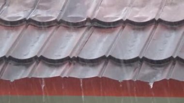 Evin çatısına yağmur damlaları yağıyor.