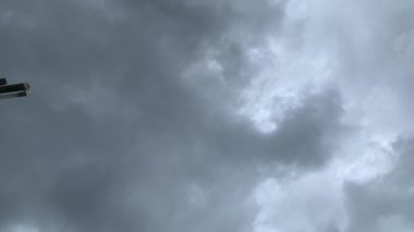 Gri, uğursuz bulutlarla dolu bulutlu bir gökyüzü. Sol kenarda bir nesnenin görüntüsü görülebilir. Bulutlu ve karamsar atmosfer.