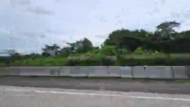 Yolculuğun zamanlaması, mavi gökyüzündeki bulutların arkaplanına karşı yoldan görülen şehri gösteriyor..