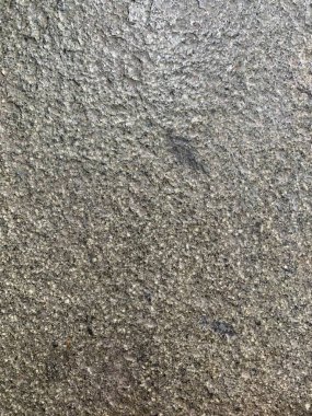 Sert ve kumlu granit taş yüzeyin yakın plan çekimi. Arkaplan, doku veya soyut tasarım ögesi için ideal.