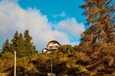 Dağların, gölün ve ağaçların üzerinde dramatik bulutlarla akşam gökyüzü. Gölün üzerinde dramatik gün batımı