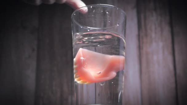 Nahaufnahme Von Prothesenzähnen Die Ein Glas Wasser Gegeben Werden Die — Stockvideo