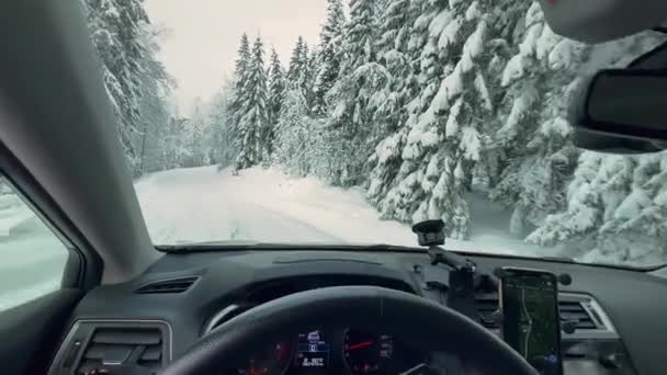 スキャンディナヴィアの冬の間に雪の森を運転しながら車からの眺め 木々や道路の厚い雪に覆われた 美しい北欧の自然 カメラはゆっくりと動き回り — ストック動画
