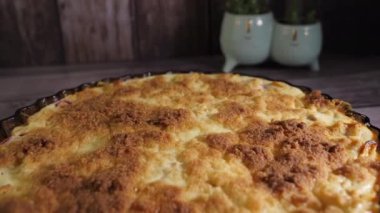 Kesme tahtasındaki cam bir şekle bürünmüş pastayı yakından çek. Tahta masa. Lezzetli ev yapımı yemekler. Arka planda kaktüs bitkileri var. Kamera sola dönerken yavaşça geri hareket ediyor.