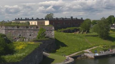 Helsinki. Finlandiya-Haziran 16.2021: Yoldan geçen bir yolcu gemisinden görülen Suomenlinna deniz kalesinin muhteşem görüntüsü. Tarihi bir olay. Popüler turist mekanı. İnanılmaz doğa ve mimari. Kamera sola hareket ediyor.