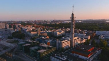 Helsinki.Finland-August 30.2021: Idyllic aerial view of the Tv tower in Helsinki Finland. Beautiful cityscape. Amazing architecture. Sunset. Drone slowly moving backwards and upwards.