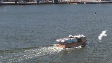 Helsinki.Finland-June 16.2021: Pretty shot of a boat sailing into the harbor of Helsinki. Beautiful cityscape. Amazing nature and sea. Tourists. Sunny day. Camera zooming out.