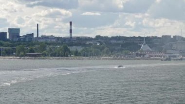 Tallinn.Estonya-28 Ağustos 2020: Okyanusta yüzen yelkenli teknesiyle Estonya 'nın Tallinn limanının uzak görüntüsü