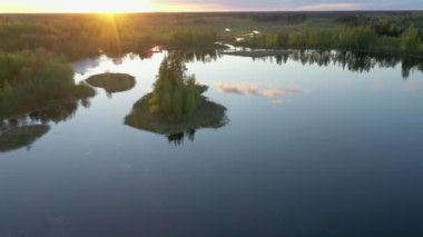 Gün batımında Ao Estonya 'da baraj gölünün ortasında küçük bir ada. Kamera yavaşça ileri gidiyor. jeoloji görüntüsü
