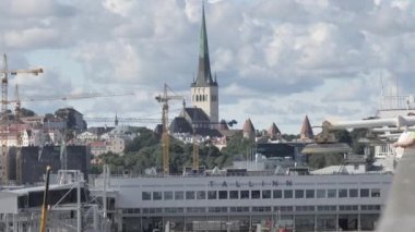 Tallinn.Estonya-28 Ağustos 2020: Estonya 'da bir yaz gününde Tallinn limanının büyük terminal binasının görünüşü. Kiliseler ve eski kasaba uzaktan görülebiliyor. Bulutlu.