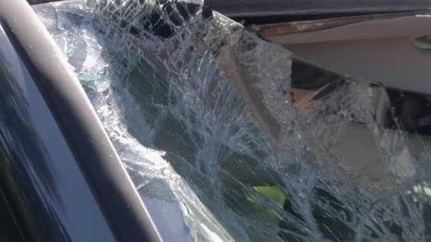 壊れたフロントガラスを示す破壊されている車の閉鎖ショット 板で窓を割った 車が故障した カメラがゆっくりとズームアウト — ストック動画