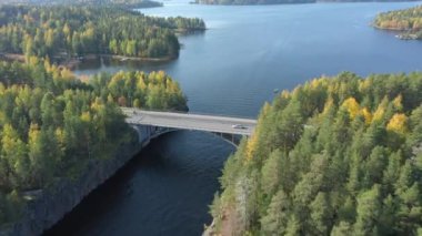 Finlandiya 'daki büyük Saimaa Gölü' nün ve adalardaki ağaçların insansız hava aracı görüntüleri. Kamera ileri yönde hızlı hareket eder. Arabalar köprüde. Rusya-Finlandiya sınırına yakın. Jeoloji videosu.