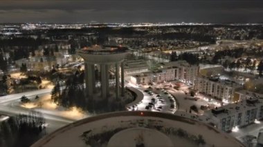 Vanta.Finlandiya-29 Aralık 2021: Hiekkaharju Vantaa 'daki eski kulenin yanındaki yeni su kulesinin havadan çekimi. Harika bir şehir manzarası. Gece vakti. Kış zamanı. Drone yavaşça geriye doğru hareket ediyor.