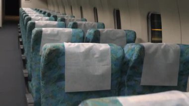 Nagoya. 31 Ekim 2019, tren vagonundaki koltuklar. Nagoya Japonya 'daki demiryolu müzesi. Pencereler ve beyaz duvarlar. Mavimsi ve beyaz koltuklar. Kamera yavaşça yukarı doğru eğiliyor.