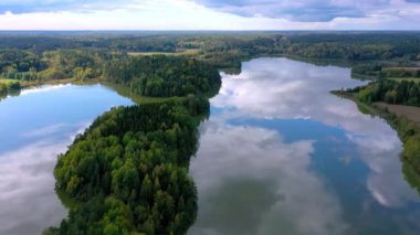 Finlandiya manzarası için güzel bir hava manzarası. Sonbahar renklerinde bir orman. Bulutlu gökyüzü göllerin yüzeyine yansıyor. Kamera soldan sağa doğru yavaşça hareket eder.