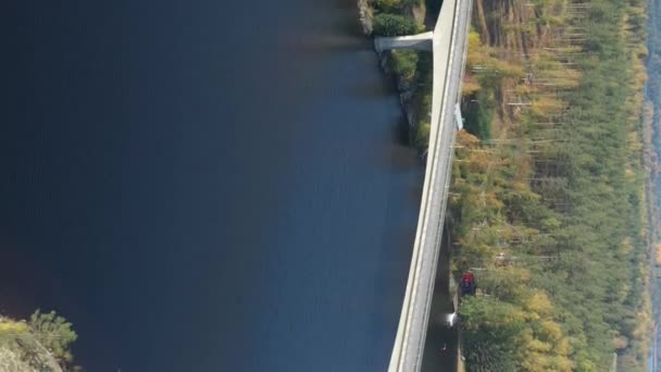 这座横跨芬兰赛马湖蓝色水域的长桥 一架无人驾驶相机在五彩斑斓的林冠和湖水上空飞驰而过 靠近俄罗斯 芬兰边境 垂直格式影片 — 图库视频影像