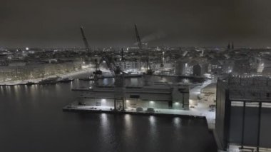 Helsinki. Finlandiya-3 Şubat 2022: Punavuori bölgesinin kışın Helsinki Finlandiya 'daki insansız hava aracı görüntüleri. Liman turnaları. Baltık deniz kıyısı. Gece silueti. Kamera yakınlaştırırken yana doğru hareket ediyor.