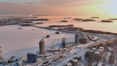 Espoo.Finland-3 Şubat 2022: Keilaranta kentinin kışın havadan çekimi. Donmuş deniz. Farklı binalar. Karlı şehir. Drone yavaşça geriye doğru hareket ediyor.
