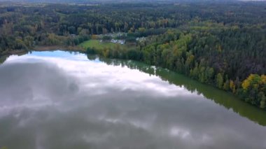 Finlandiya 'da ağaçların etrafındaki gölün hava manzarası güneşli bir günde karavan bölgesinde.