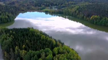 Finlandiya 'daki karavan bölgesinde göl suyunun gökyüzündeki bulutların manzarası. Kamera yavaşça ileri gider..