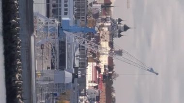 Tallinn.Estonya-14 Ekim 2021: Tallinn 'in bir yolcu gemisinden müthiş görüntüsü. Liman. Arka planda eski bir kasaba. Bulutlu gökyüzü. Turizm. Kamera yavaşça yana hareket ediyor. Dikey Biçim Videosu