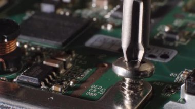 Farklı küçük parçalar. Bir vidanın sabit diske vidalandığı yakın çekim. Tornavida. Bilgisayar teknolojisi tamir ediliyor. Mikroçip. Depo. Seçici odak.