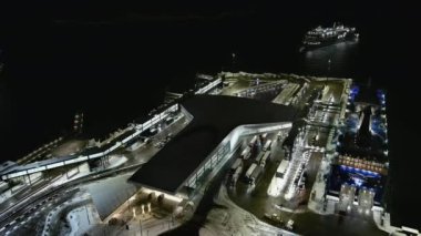 Helsinki. Finlandiya-18 Ocak 2022: Bir gemiye binen kamyonların havadan görüntüsü ve limana yaklaşan başka bir gemi. Lansisatama. Kış zamanı. Gece vakti. Ulaşım.