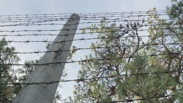 仔细看栅栏上有刺的铁丝网 后面有树木 相机慢慢地倒转 — 图库视频影像