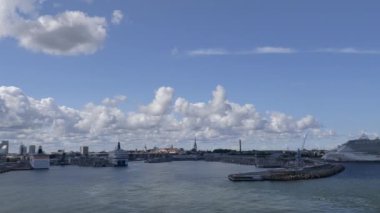Tallinn.Estonya-21 Temmuz 2021: Tallinn 'in denizden muhteşem görüntüsü. İnanılmaz şehir mimarisi. Liman. Yolcu gemileri. Bulutlu ve mavi gökyüzü. Panoramik. Kamera yavaşça sola dönüyor..