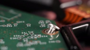 Farklı bileşenler. Bilgisayar teknolojisi tamir ediliyor. Bir sabit diskin mikroçip görüntüsü ve vida. Depo. Seçici odaklanma. Kamera yavaşça yana hareket ediyor.