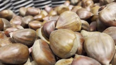 Süpermarkette yenebilir kestanelerin yakın plan çekimi. Koyu ve açık kahverengi. Yiyecekler. Kamera yavaşça geriye hareket ediyor.