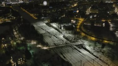 Helsinki. Finlandiya-18 Ocak 2022: Helsinki Finlandiya şehir merkezinde bir trenin insansız hava aracı görüntüsü. Gece vakti. Şehir manzarası. Ulaşım. Kış zamanı. Kamera yavaşça geriye hareket ediyor.