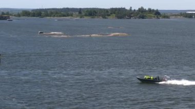 Helsinki. Finlandiya-Haziran 16.2021: Helsinki kıyı adaları arasında sürat teknesinin muhteşem bir görüntüsü. Güneşli bir günde güzel bir doğa ve deniz. Kamera sola hareket ediyor.