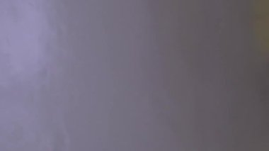 Araba yıkama makinesindeki büyük sarı fırça daha yakından görüldüğü gibi. Basınçlı yıkama. Ön cama sıçramış. Dikey Biçim Videosu 