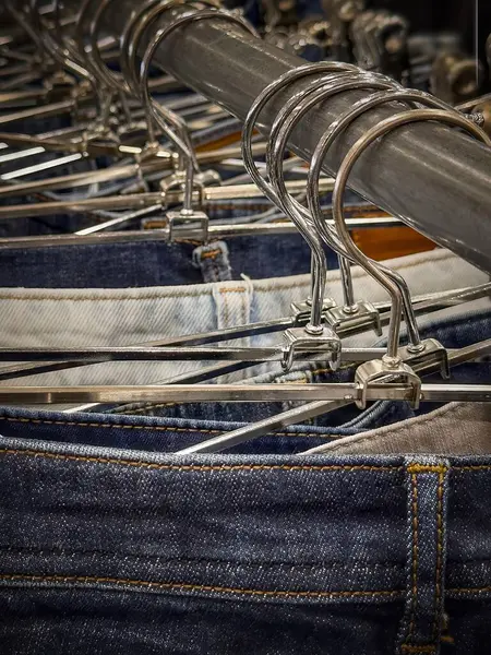 Denim kotları, perakende mağazasındaki askılara göre düzenlenir. Yeniden kullanım ve geri dönüşüm odaklıdır. Sürdürülebilir moda seçimlerini teşvik eder ve müşterileri ikinci el kıyafet seçmeye teşvik eder..