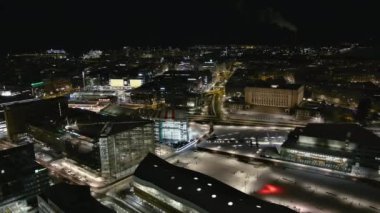 Helsinki. Finlandiya-18 Ocak 2022: Helsinki şehir merkezinin insansız hava aracı görüntüleri. Aydınlanmış. Mimarlık. Kış zamanı. Gece vakti. Kamera yavaşça yana hareket ediyor.