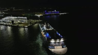 Helsinki. Finlandiya-18 Ocak 2022: Bir yolcu gemisinin liman yakınlarında manevra yaparken görüntüsü. Karanlık. Kış zamanı. Gece vakti. Arka planda gemi turu. Kamera feribotun dönüşünü izliyor..