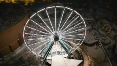 Helsinki. Finlandiya-18 Ocak 2022: Linnanmaki eğlence parkının kışın havadan çekimi. Eğlence. Gece vakti. Işıklı dönme dolap. Drone yavaşça geriye doğru hareket ediyor.