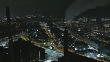 Helsinki. Finlandiya-31 Aralık 2021: Ruoholahti Helsinki 'nin yeni yıl arifesinde havadan çekimi. Güzel şehir manzarası. Havai fişekler. Gece vakti. Dumanı tüten bacalar. İHA uzaklaşırken yavaşça yana hareket ediyor.