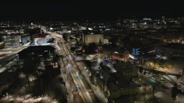 Helsinki. Finlandiya-18 Ocak 2022: Helsinki Finlandiya şehir merkezinde bir tramvay yolculuğunun havadan çekimi. Tramvay. Toplu taşıma. Şehir manzarası. Gece vakti. Kış zamanı. Drone yavaşça geriye doğru hareket ediyor.