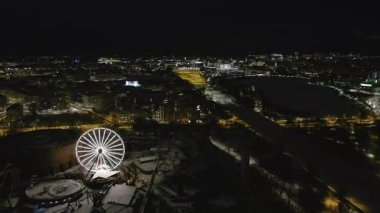 Helsinki. Finlandiya-18 Ocak 2022: Linnanmaki eğlence parkındaki farklı araçların insansız hava aracı görüntüleri. Gece vakti. Eğlence. Dönme dolap. Kışın kapalıydı. Kamera geri gidiyor.