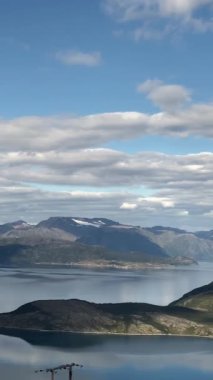 Norveç 'teki fiyort manzarası çok güzel. Mavi gökyüzünde beyaz bulutlar. Dikey video