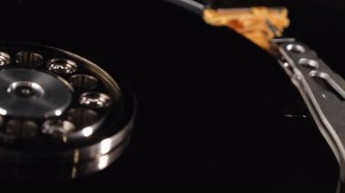 Yakın çekim bir sabit diskin içini ve farklı bileşenleri gösteriyor. Depo. Teknoloji. Metalik. Arka plan bulanık. Seçici odaklanma. Kamera yavaşça hareket ediyor.