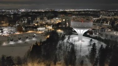 Vanta.Finlandiya-29 Aralık 2021: Vantaa 'daki yeni Hiekkaharju su kulesinin eski kulesiyle birlikte insansız hava aracı görüntüsü. Gece vakti. Harika bir şehir manzarası. Kış zamanı. Kamera yavaşça yana hareket ediyor.