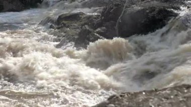 Küçük bir şelalenin yakın çekimi. İskandinavya 'da bahar doğası harikadır. Kamerayla çekilen yer çekimi çok hafif ilerledi..