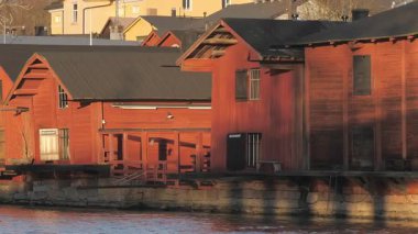 Porvoo.Finland-12 Aralık 2020: Porvoo Finland 'da nehir kenarındaki kırmızı evlerin daha yakın çekimleri cennet mimarisini gösteriyor. Kamera yavaşça uzaklaşıyor.